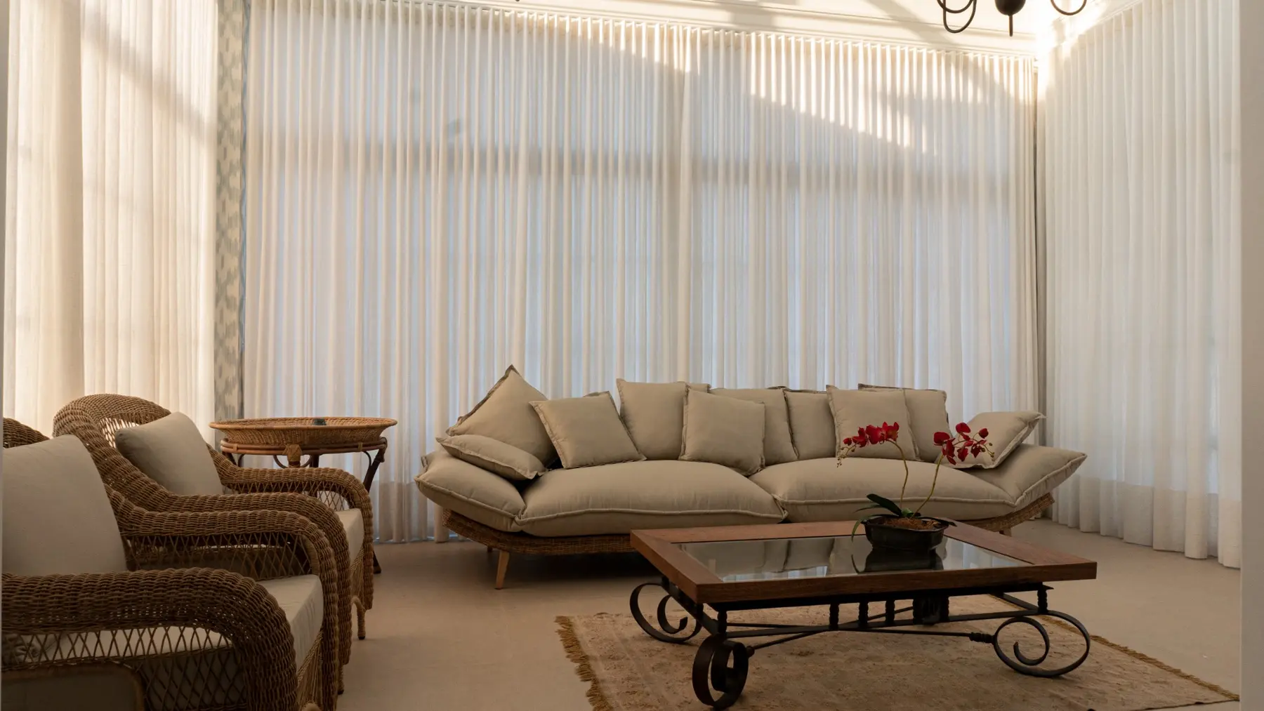 Sala de estar ampla com cortinas brancas sob medida
